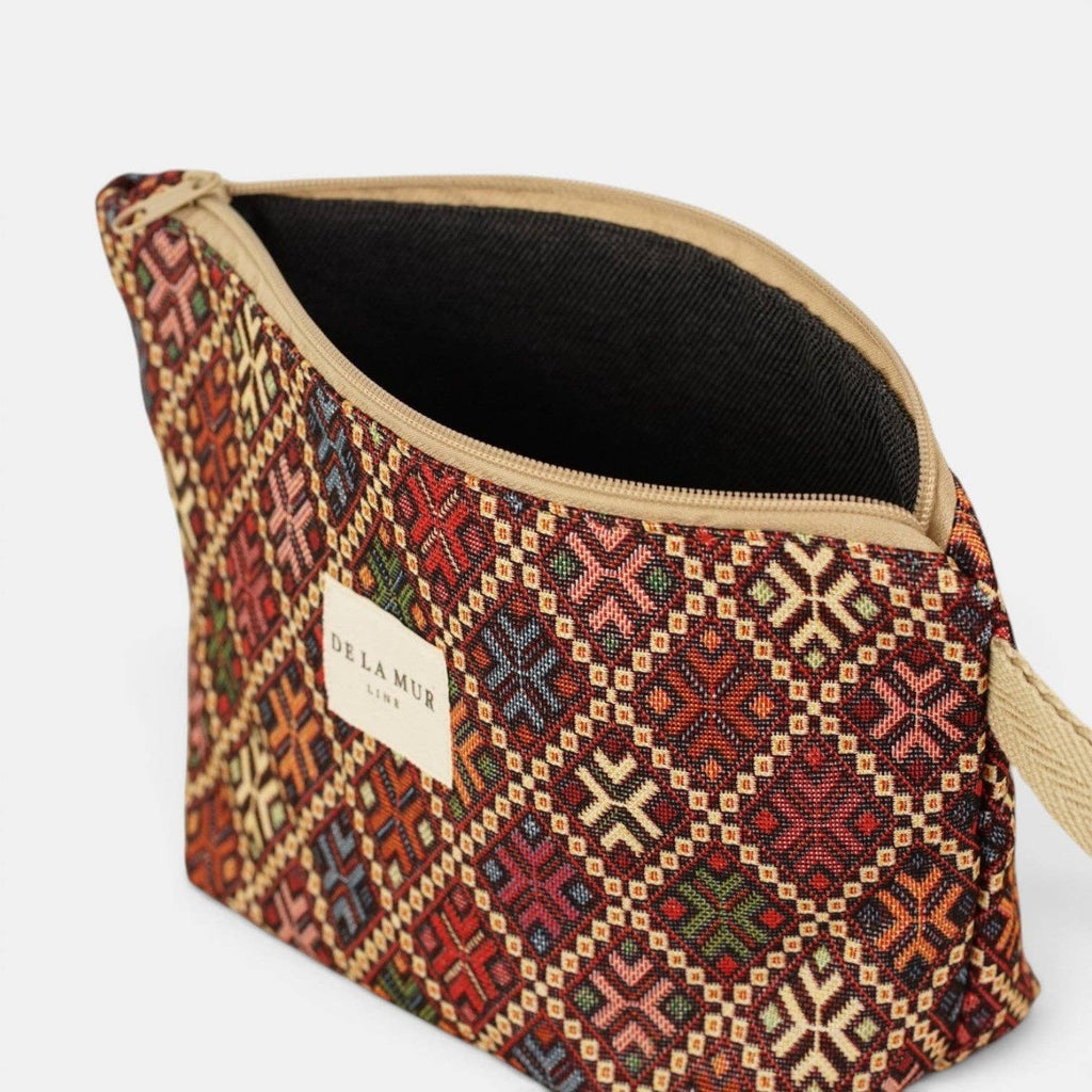 Large burgundy geometric jacquard makeup bag unzipped to show the dark lining