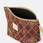 Large burgundy geometric jacquard makeup bag unzipped to show the dark lining
