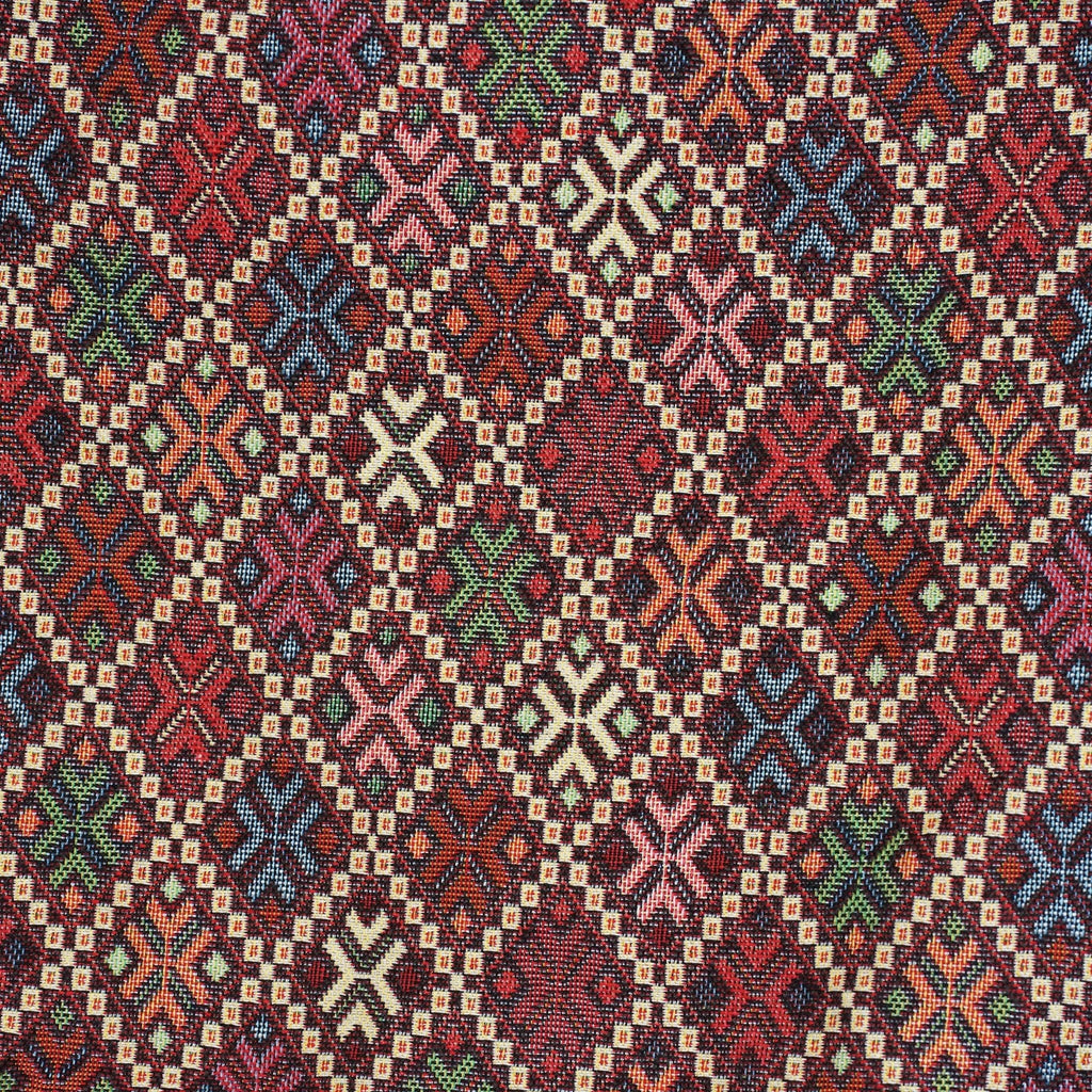 Close-up of the woven kilim-style diamond and cross pattern on burgundy