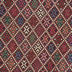 Close-up of the woven kilim-style diamond and cross pattern on burgundy