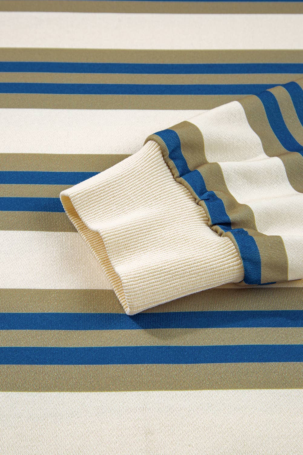 Folded beige and brown striped fabric on a striped background
