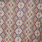 Close-up of the woven jacquard pattern on the red, green and cream geometric jacquard glasses case