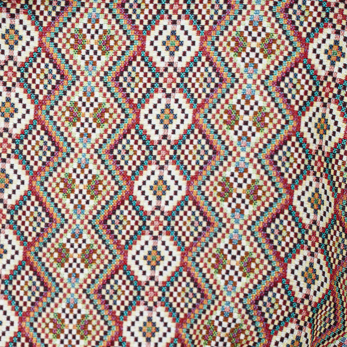Close-up of the woven jacquard pattern on the red, green and cream geometric jacquard glasses case