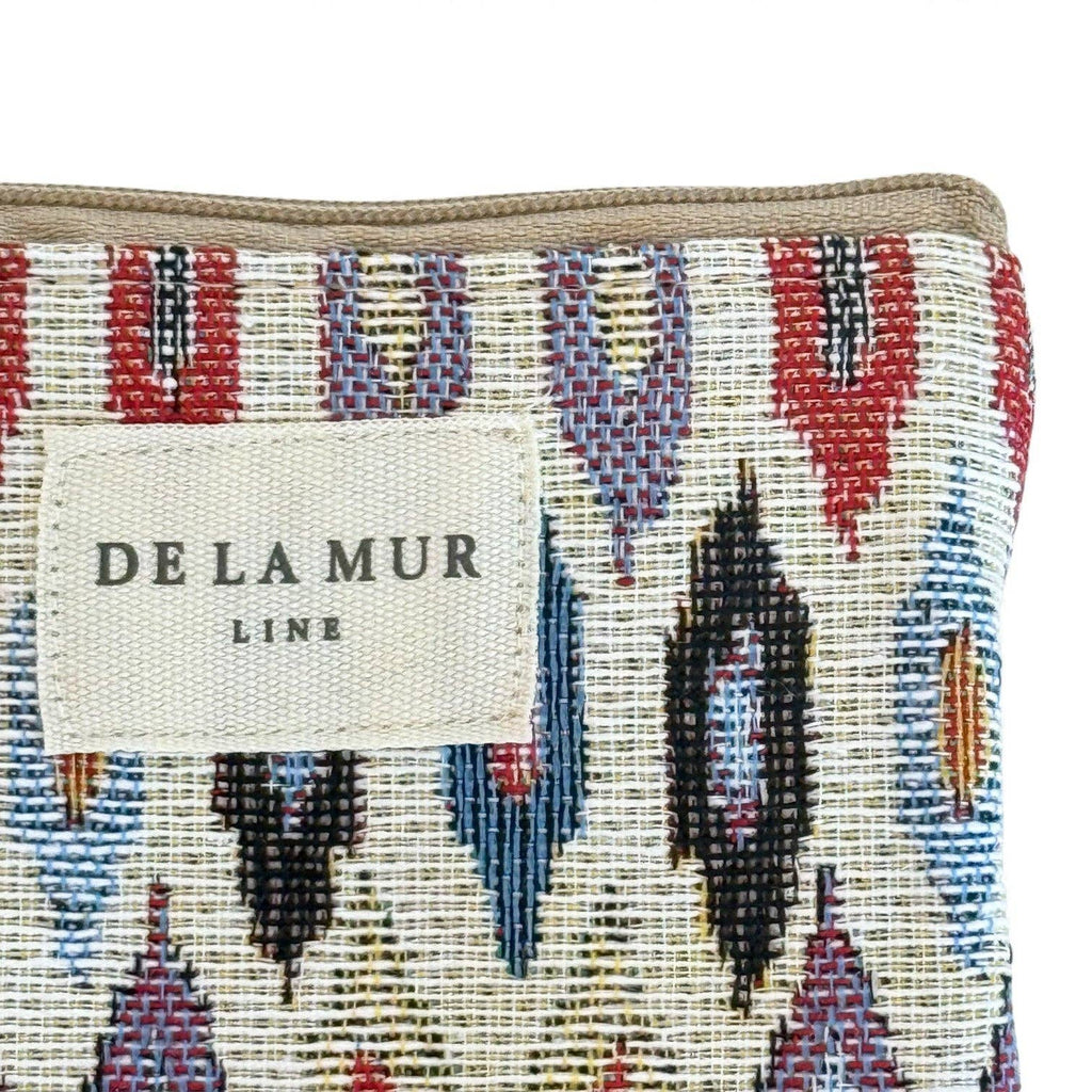 Close-up of the De La Mur label on the multicolor ikat jacquard glasses case with beige trim