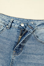 Close-up of blue denim jeans with a zipper and button on a beige background