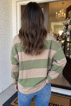 A woman wearing a long-sleeve top with horizontal stripes in sage green and beige, paired with blue jeans.