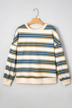 A long-sleeve crewneck sweatshirt with horizontal stripes in blue, olive green, and cream, hanging on a wooden hanger against a light gray background.