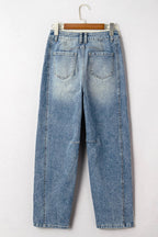 Pair of blue jeans on a hanger against a white background